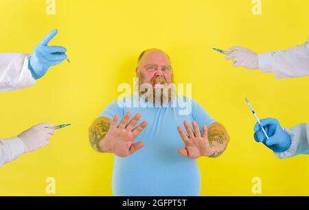 Fat doubter man has doubts about covid-19 vaccine Stock Photo