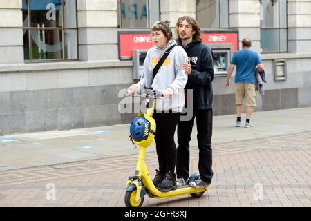 Young couple, on rented electric scooter, in Nottingham Stock Photo