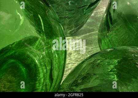 Abstract Detail Green Glass Demijohns Blue Sky. Big Bottles. Reflections and flashes of water drops. Stock Photo