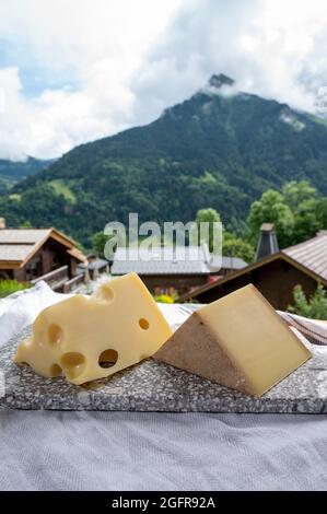 Cheese collection, Swiss cow cheese emmental and gruyere and mountains village in Apls in summer 2on background Stock Photo