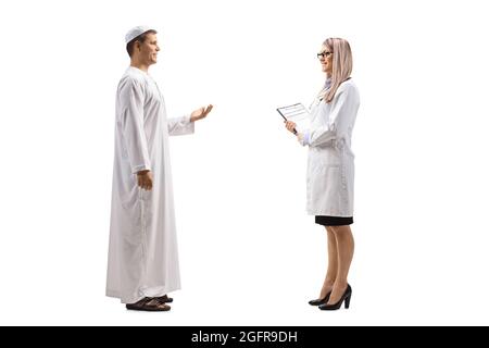 Full length profile shot of a young man in ethnic clothes talking to a female doctor isolated on white background Stock Photo