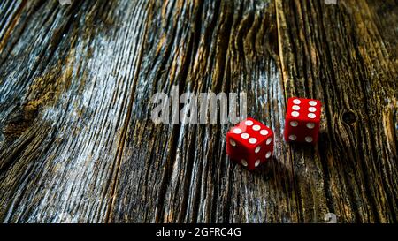 Two red  dice on rustic wooden table with copy space Stock Photo