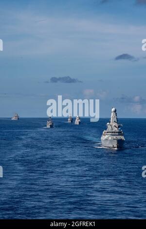 PHILIPPINE SEA (Aug. 24, 2021) From left to right, USS New Orleans (LPD 18), Royal Navy frigate HMS Kent (F 78), USS The Sullivans (DDG 68), Royal Netherlands Navy frigate HNLMS Evertsen (F 805), and Royal Navy destroyer HMS Defender (D 36) trail the forward-deployed amphibious assault ship USS America (LHA 6) during a photo exercise. America, flagship of the America Expeditionary Strike Group, along with the 31st MEU, is operating in the U.S. 7th Fleet area of responsibility to enhance interoperability with allies and partners and serve as a ready response force to defend peace and stability Stock Photo