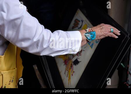 A couple admires contemporary Native American ledger mixed-media paintings by Blackfeet ledger artist Terrance Guardipee in Santa Fe, New Mexico. Stock Photo