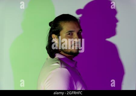 side view of a latino and bearded gay young man in studio Stock Photo