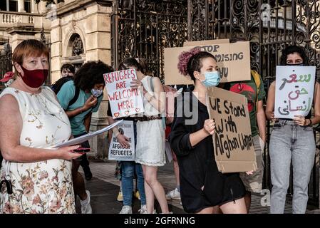 Dublin, Ireland. 26th Aug, 2021. Protesters hold placards during the demonstration.Dozens of people gathered in front of Ireland's parliament building, Leinster House, to demand that the Irish government welcomes more Afghan refugees. United Against Racism organized the protest, while other parties and organizations such as People Before Profit, ROSA, and Le Chéile were also present. Protesters argued that since the Irish government had previously allowed the US military to use Shannon Airport, Ireland should no longer refuse to accept refugees. Credit: SOPA Images Limited/Alamy Live News Stock Photo