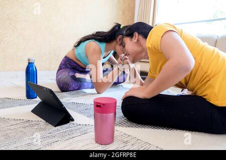 Closeup of two girls competing in arm-wrestling at home. Stock Photo