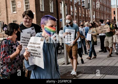 Protesters hold placards during the demonstration.Dozens of people gathered in front of Ireland's parliament building, Leinster House, to demand that the Irish government welcomes more Afghan refugees. United Against Racism organized the protest, while other parties and organizations such as People Before Profit, ROSA, and Le Chéile were also present. Protesters argued that since the Irish government had previously allowed the US military to use Shannon Airport, Ireland should no longer refuse to accept refugees. (Photo by Natalia Campos/SOPA Images/Sipa USA) Stock Photo