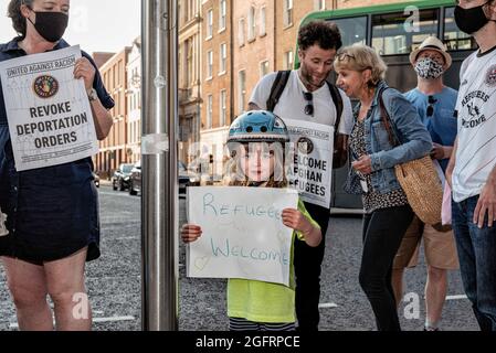 Protesters hold placards during the demonstration.Dozens of people gathered in front of Ireland's parliament building, Leinster House, to demand that the Irish government welcomes more Afghan refugees. United Against Racism organized the protest, while other parties and organizations such as People Before Profit, ROSA, and Le Chéile were also present. Protesters argued that since the Irish government had previously allowed the US military to use Shannon Airport, Ireland should no longer refuse to accept refugees. (Photo by Natalia Campos/SOPA Images/Sipa USA) Stock Photo