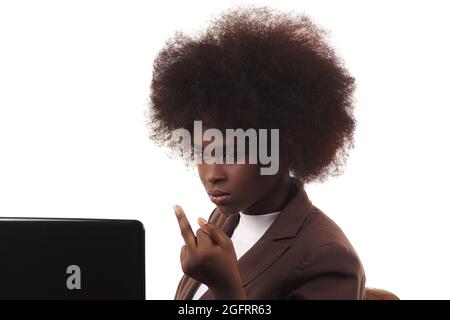 Young black Hispanic Latina business executive woman, with afro hair, with angry gesture looking at her laptop, in white background Stock Photo