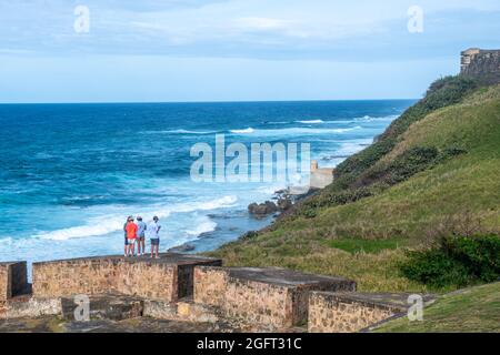 Some men watch the ocean on the walls of Castillo San Felipe del Morro. - Puerto Rico Stock Photo