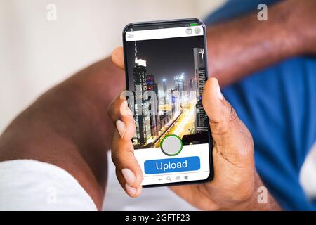 African American Man Uploading Mobile Phone Photo Online Stock Photo