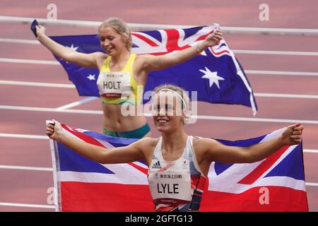 Tokio, Japan. 27th Aug, 2021. Paralympics: Athletics, 100m, women, final, at Olympic Stadium. Silver medallist Isis Holt from Australia and bronze medallist Maria Lyle from Great Britain hold national flags in their hands. Credit: Marcus Brandt/dpa/Alamy Live News Stock Photo