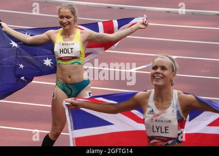 Tokio, Japan. 27th Aug, 2021. Paralympics: Athletics, 100m, women, final, at Olympic Stadium. Silver medallist Isis Holt from Australia and bronze medallist Maria Lyle from Great Britain hold national flags in their hands. Credit: Marcus Brandt/dpa/Alamy Live News Stock Photo