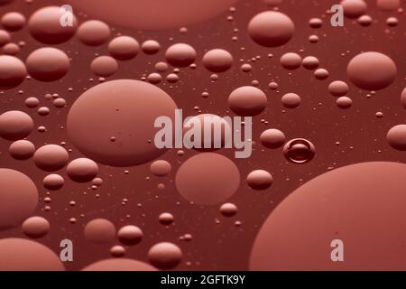 Bubbles of oil in water making an interesting dark pink macro pattern Stock Photo