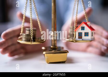 House And Asset Market Protection. Coins On Weight Scale Stock Photo