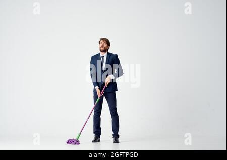 business man in a suit with a mop in his hands cleaning service Stock Photo