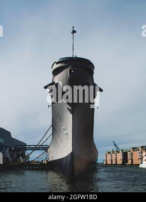 A head-on view of a war ship in Norfolk, Virginia. Taken on a bright sunny day with the water visible below. Stock Photo