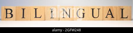 The word bilingual was created from wooden cubes. Education and business. Close-up. Stock Photo