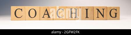 The word coaching was created from wooden cubes. work and study. Close-up. Stock Photo