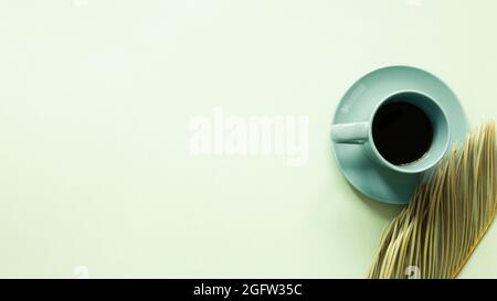Mint cup of coffee with tropical leaf on green background. top view, copy space Stock Photo