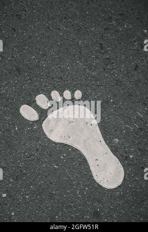 Painted Footprint On Asphalt . Vertical shot , close up Stock Photo