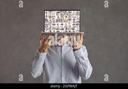 Man showing laptop screen during conference call with lots of diverse business people Stock Photo