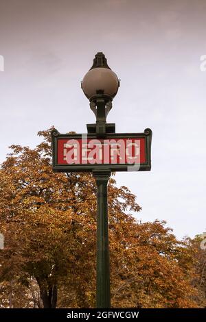 Traditional parisian metro (underground, subway) sign with old, historical building in the background in Paris. Stock Photo