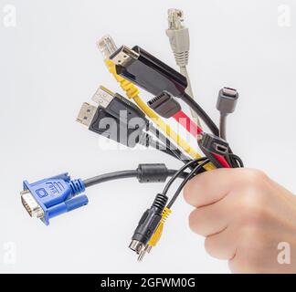 cables in hand isolated on white background. bundle of computer interface cables. Stock Photo