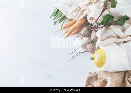 Fresh vegetables in eco cotton bags on the table.top view. tomatoes, cucumbers, carrots, beets, beans, potatoes, pumpkin. zero cost trading concept. p Stock Photo