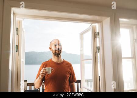 Smiling man holding mug with coffee Stock Photo