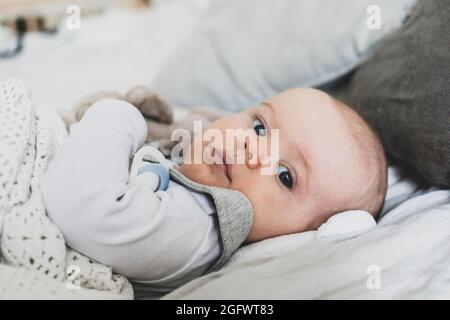 Baby lying in bed Stock Photo