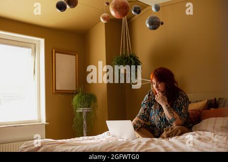 Woman on  bed using laptop Stock Photo