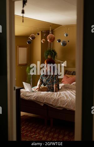 Woman on  bed using laptop Stock Photo