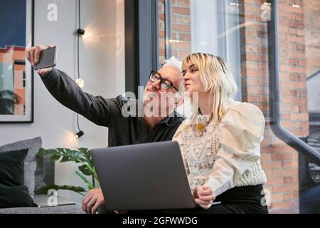 Coworkers taking selfie in office Stock Photo