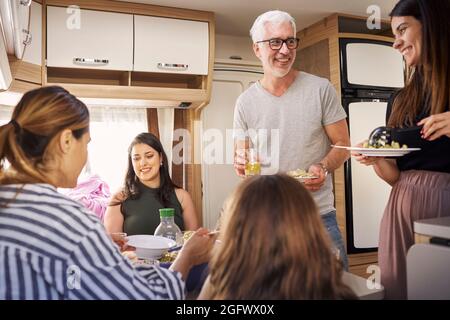 Family having meal in camper van Stock Photo