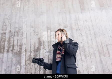 Young man in winter clothing talking on phone Stock Photo