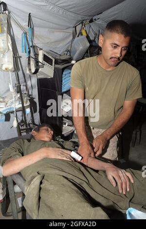 080720-M-1341G-005 FARAH PROVINCE, Afghanistan (July 20, 2008) U.S. Navy Hospital Corpsman 2nd Class Luis Anaya, assigned to Golf Company, 2nd Battalion, 7th Marine Regiment, treats an Afghan boyÕs foot at the Baqwa forward operating base in the Farah Province. Based out of Marine Air Ground Combat Center, Twentynine Palms, Calif., 2nd Battalion 7th Marine Regiment is a reinforced light infantry unit deployed to Afghanistan in support of Operation Enduring Freedom. (U.S. Marine Corps photo by Cpl. Jason T. Guiliano/Released)