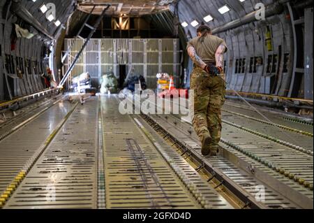 Senior Airman Anna Crocker, 9th Airlift Squadron loadmaster, performs a pre-flight wench check on a C-5M Super Galaxy before takeoff to Hamid Karzai International Airport, Afghanistan from Dover Air Force Base, Delaware, Aug. 16, 2021. Air Mobility Airmen play a key role in ensuring safe departure of U.S. and allied personnel from Afghanistan via civilian and military flights. (U.S. Air Force photo by Senior Airman Faith Schaefer) Stock Photo