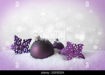 Purple christmas ball and stars on snow, sparkling white background, vignette effect, copy or text space. Stock Photo