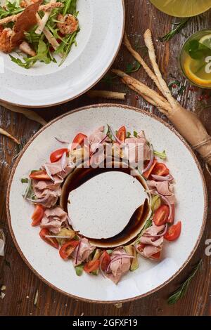 salads with boiled pork and shrimp on a wooden table with sauces Stock Photo
