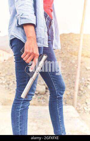 Gun in the hands of a girl, close-up arms. Stock Photo