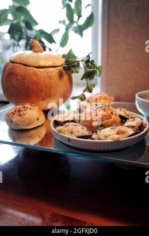 Hot homemade soup with mussels, vegetables and cream, served in the pumpkin, with homemade sesame buns Stock Photo