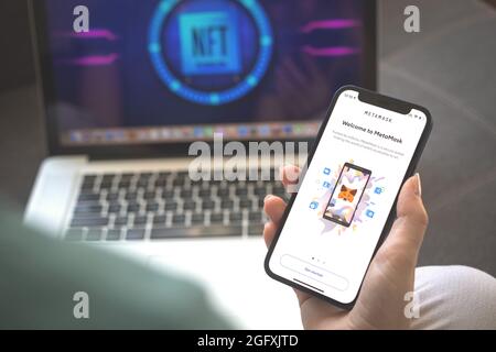 Kharkov, Ukraine - August 23, 2021: MetaMask app logo on mobile phone screen. Woman using Meta Mask application photo Stock Photo