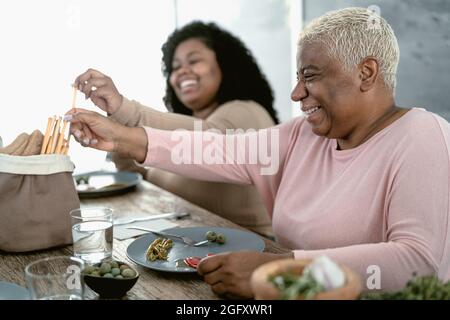 Happy Hispanic mother and daughter having healthy lunch at home Stock Photo