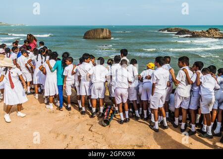 GALLE, SRI LANKA - JULY 12, 2016: Children in school uniforms watch a sea from fortification walls of Galle. Stock Photo