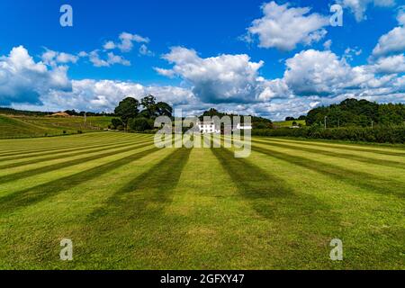 A freshly cut school field on a summers day with clouds in the sky Stock Photo