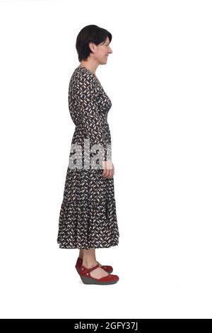 side view of a full portrait of a woman with long dress smiling and  looking  on white background Stock Photo