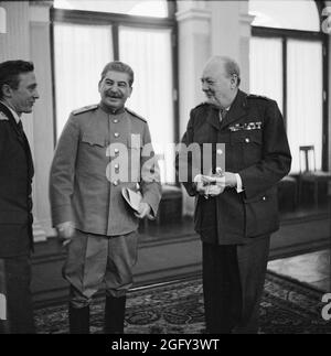 Winston Churchill laughing with Joseph Stalin in the conference room at Livadia Palace during the Yalta Conference. On the left is  Stalin's interpreter Vladimir Pavlov Stock Photo
