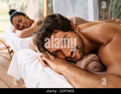 Beautiful couple getting a back massage on Bali resort, romantic weekend and relax. Couple massage at wellness spa Stock Photo